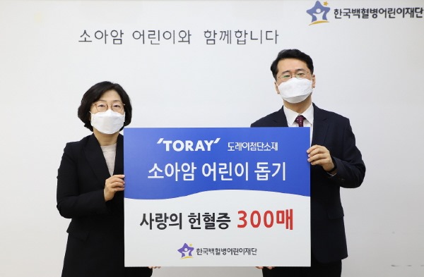 도레이첨단소재 김은주 상무(왼쪽)가 헌혈증 300매를 서선원 한국백혈병어린이재단 사무총장에게 전달하고 있다.JPG